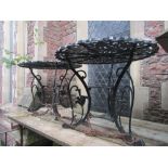 A pair of painted cast aluminium garden terrace tables of circular form with pie crust outline and