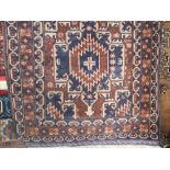 Persian floor rug decorated with blue medallions upon a brown ground, 130 x 82 cm