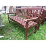 A contemporary stained hardwood three seat garden bench with slatted seat and back, 5 ft long