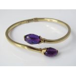 A hinged 9ct gold torque bangle with amethyst coloured faceted stones, 11.5g