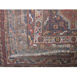 Three similar Persian floor rugs all with red medallions upon a navy blue ground with brown and