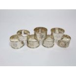 Seven various silver napkin rings to include a Chinese silver example decorated in relief with