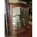 A late 19th century wall mirror the walnut frame with shaped outline and trailing floral detail