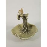 An early 20th century continental table centre in the Royal Dux manner in the form of a lady with