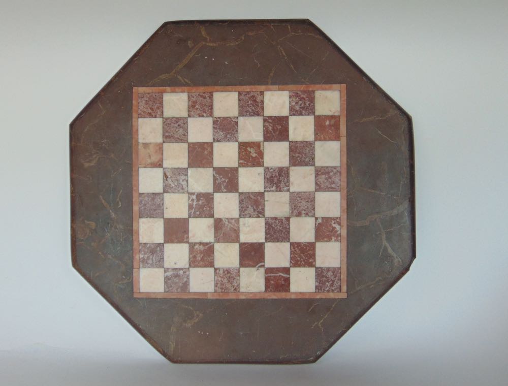 An inlaid marble checker board the octagonal piece with moulded borders 40 x 40 cm approx.