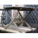 A contemporary weathered teak garden table, the octagonal slatted panelled top raised on folding X