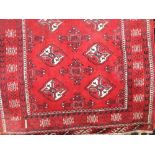 A Bokhara floor runner decorated with medallions upon a red ground, 270 x 90 cm approx