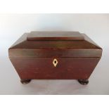 A 19th century sarcophagus tea caddy with partly fitted interior.