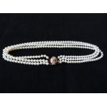 A three strand pearl necklace with diamond clasp