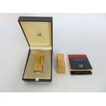 A boxed containing two gold plated Dunhill lighters with engine turned decoration