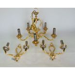 A cast polished gold coloured metal five branch electrolier together with a pair of matching wall