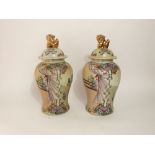 A pair of reproduction oriental vases and covers with painted female character and floral decoration