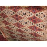 Bokhara type rug decorated with geometric red medallions on a beige ground 200cm x 150cm