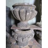 Three weathered cast composition stone garden urns of lobed circular squat form.