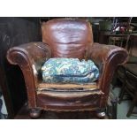A pair of Edwardian club armchairs upholstered in hide raised on bun feet(for restoration).