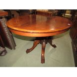 A Victorian walnut loo table the oval top raised on a carved quadraped base and inlay detail.