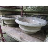 Two similar weathered cast composition stone garden planters of circular tapered and banded form,