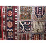 Large Eastern floor rug decorated with geometric square panels of various foliage, upon a red and