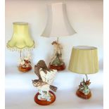 Three various figural porcelain table lamps, one modelled as a seated pauper boy, the other with