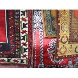 Four various floral rugs to include a modern silk example, an Afghan example on red ground and two