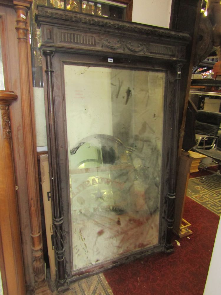 A late 19th century floorstanding mirror, the rectangular bevelled edge plate set within a carved