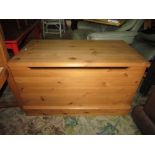 A modern pine blanket box with hinged lid and moulded plinth