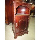 An Edwardian mahogany bedside or lamp table, the lower section enclosed by a carved and panelled