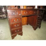 A reproduction Georgian style mahogany pedestal desk fitted with nine drawers with inset green