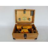 A Carl Zeiss theodolite, the scope in a branded wooden case upon an orange and galvanised steel