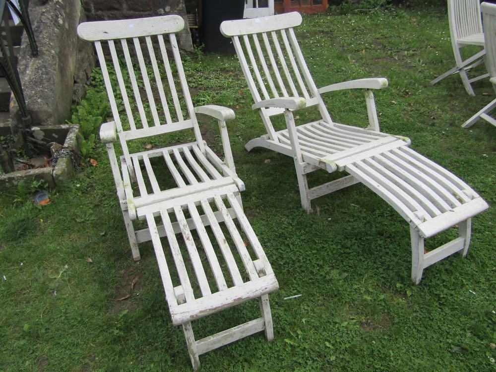 A pair of teak steamer type folding garden armchairs with slatted seats and backs (later painted