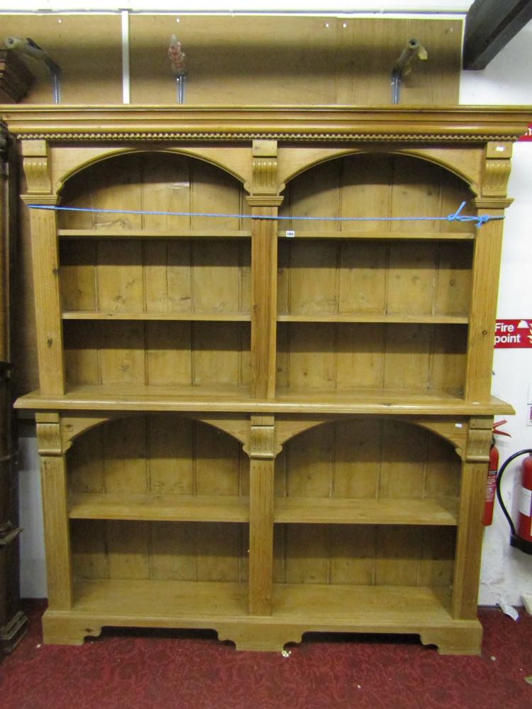 A stripped and waxed pine two sectional bookcase/display shelves with architectural mouldings and