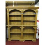 A stripped and waxed pine two sectional bookcase/display shelves with architectural mouldings and