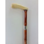 A bamboo shafted ladies walking stick with ivory handle and silvered band.