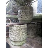 A pair of weathered cast composition stone garden planters of cylindrical form with relief detail