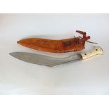 Kukri with ivory handle within a tan leather scabbard