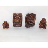 Pair of Japanese carved grotesque wooden masks together with two further carved Okimono type figures