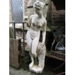 A weathered cast composition stone garden ornament in the form of a classical female figure in