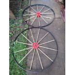 A pair of vintage cast iron twelve spoked implement wheels with iron hubs and painted finish, 115 cm