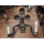 Set of four heavy ironwork wall lights of foliate design in the arts and crafts style