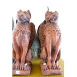 A pair of cast composition stone garden ornaments or pillar caps/finial's in the form of Griffin's