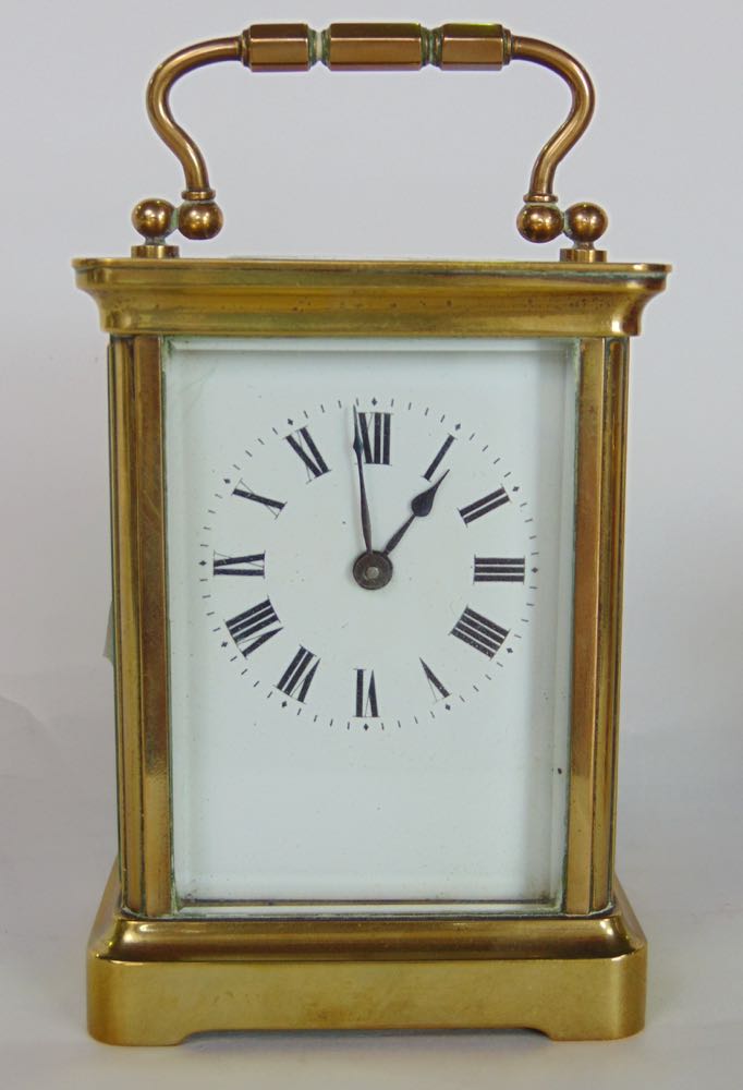 Brass carriage clock in cornice case with enamelled dial, the back plate engraved with a striding