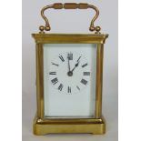 Brass carriage clock in cornice case with enamelled dial, the back plate engraved with a striding