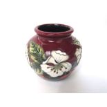 A boxed Moorcroft vase in the Cherry Blossom pattern and graduated red ground, with impressed and