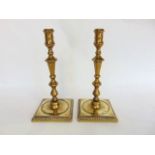 A pair of 18th century cast brass turned candlesticks on stepped square bases, 26 cm high approx