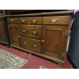 A Georgian style oak dresser base fitted with a T shaped arrangement of five drawers flanked by