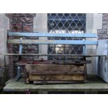 A two to three seat garden bench with open painted and weathered wooden slatted seat and back raised