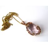 A 9ct necklace with oval pink quartz pendant in scrolling diamond set mount, 5.5g