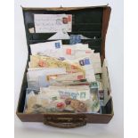 A small leather suitcase containing a quantity of unsorted stamps, some attached to envelopes,