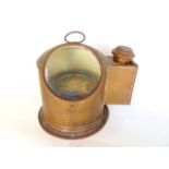 A copper cased ships binnacle compass with circular glass viewing panel and lamp box to the side,