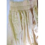 A pair of pale gold curtains in dupion silk, lined and interlined with edge trim and tie backs,